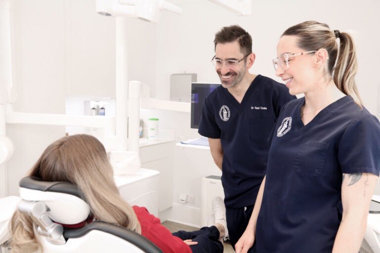 Two Clinicians Reassuring A Patient At The Chair